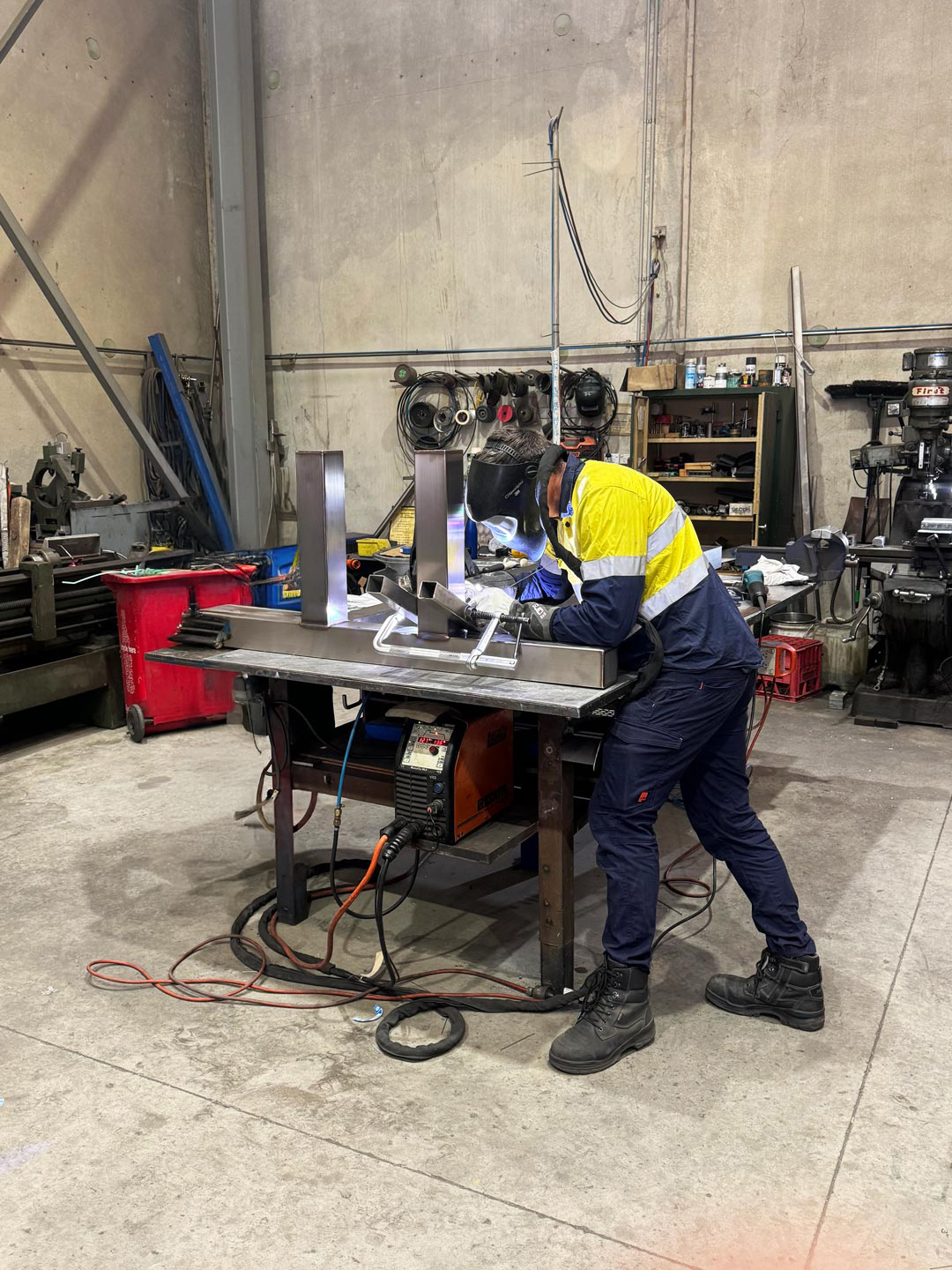 sydney-metal-fabrication-specialists two metal fabrication workers welding at work bench in industrial setting